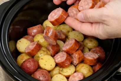Thumbnail for Drop sliced kielbasa over raw baby potatoes, together with 3 simple items, into slow cooker for a hearty weeknight dinner that disappears faster than anything else
