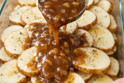 Thumbnail for Pour savory beef gravy over raw sliced russet potatoes, along with 1 other ingredient, into a glass casserole dish for a cozy dinner that’s my default when I don’t know what to make