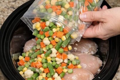 Thumbnail for Dump frozen mixed vegetables over chicken breasts, combined with 3 ingredients, into slow cooker for a hearty comfort meal that’s my default when I