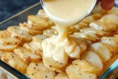 Thumbnail for Pour condensed cream of chicken soup over raw sliced russet potatoes, coupled with 1 ingredient, into a glass casserole dish for a comforting meal tha.